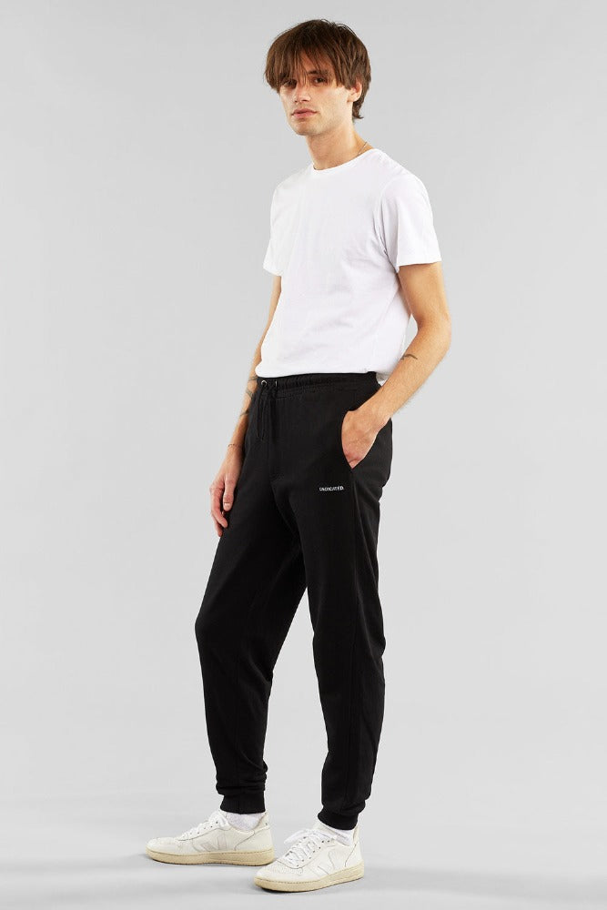 Mens joggers made by Dedicated Black  organic cotton with twin pockets and small Dedicated logo on left leg